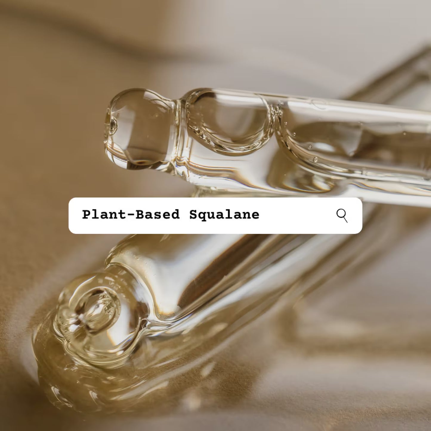 Two glass droppers with plant-based squalane oil on a reflective surface.