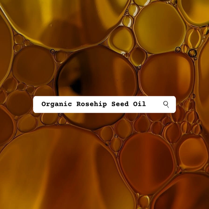 A close-up abstract background of golden and amber liquid droplets with a white search bar overlay reading 'Organic Rosehip Seed Oil'.
