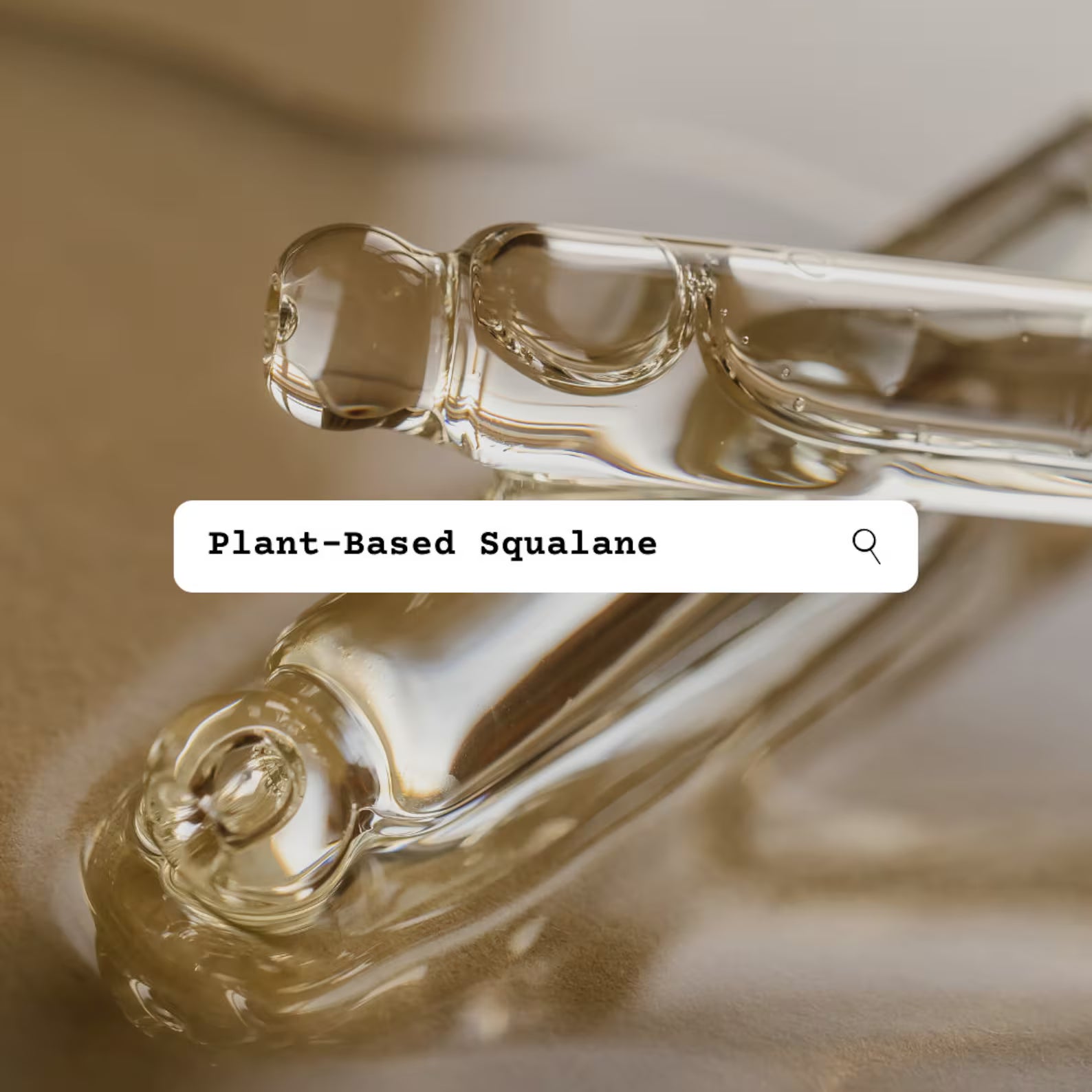 Two glass droppers with plant-based squalane oil on a reflective surface.