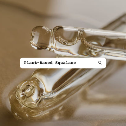 Two glass droppers with plant-based squalane oil on a reflective surface.